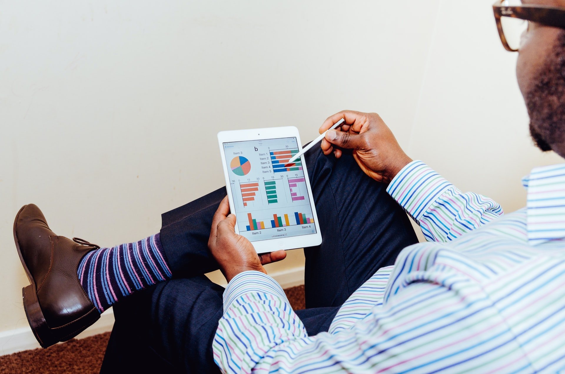 A man looking at data analytics on a tablet.