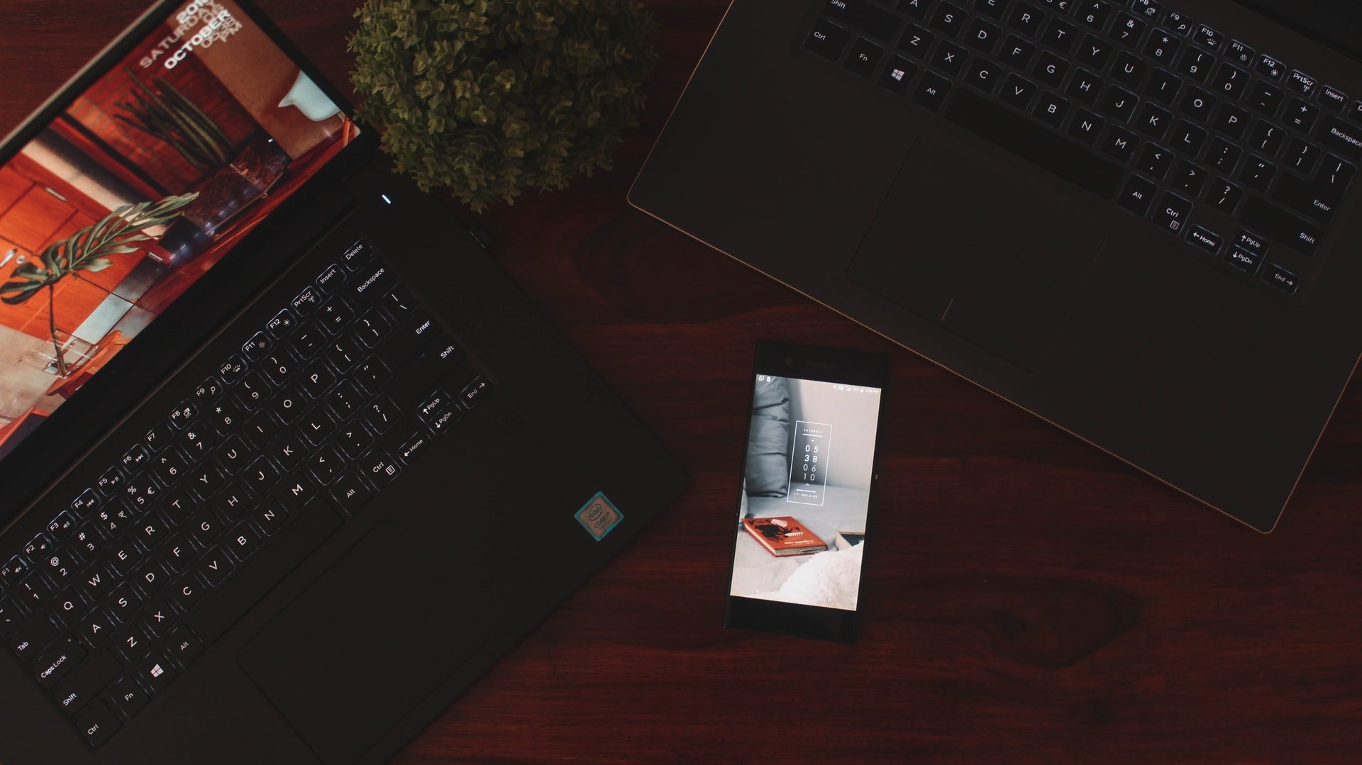 A smartphone and two laptops.