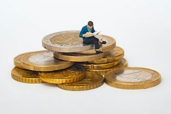 A man sitting on giant coins.