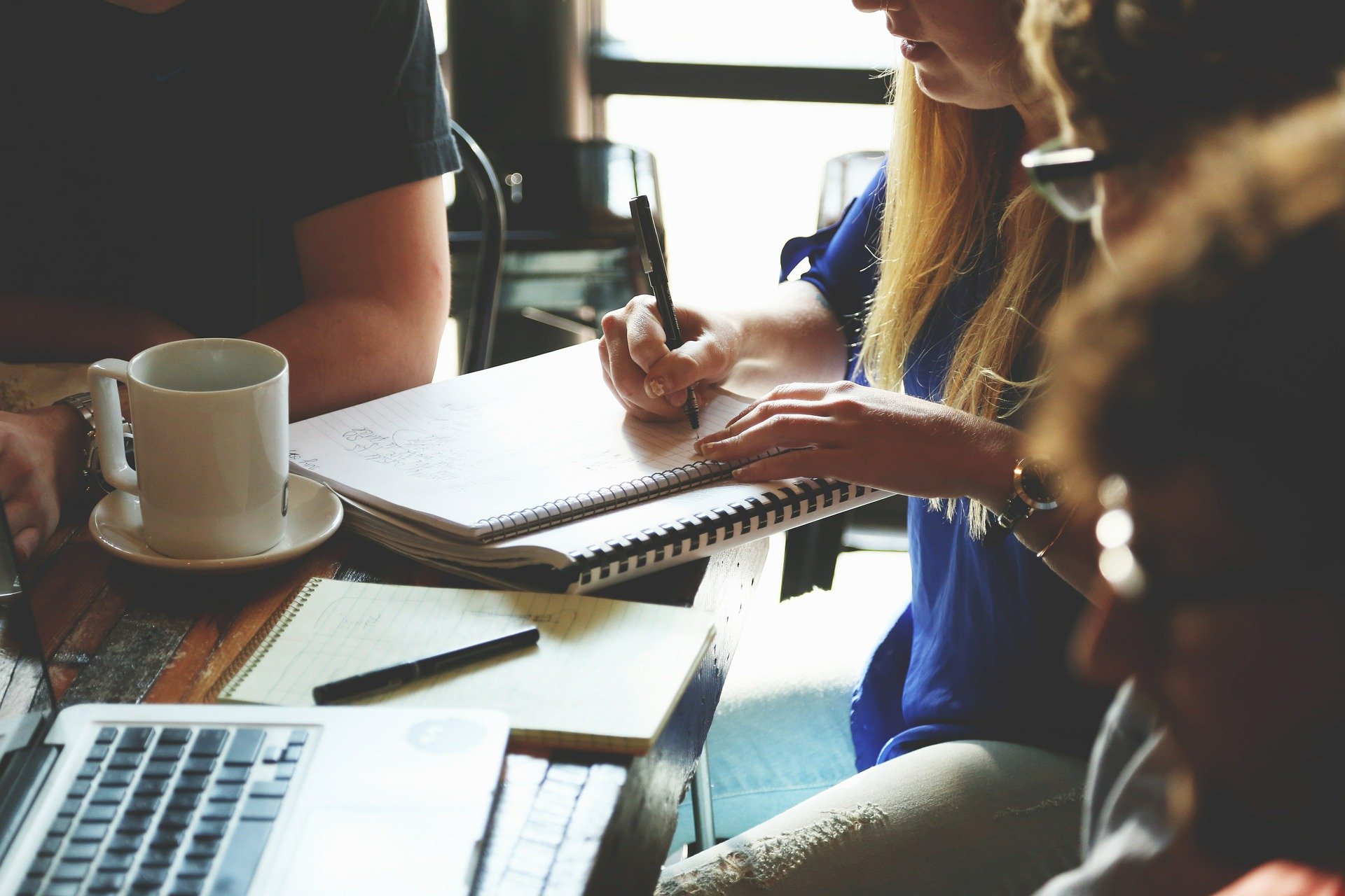 People taking notes at a meeting.